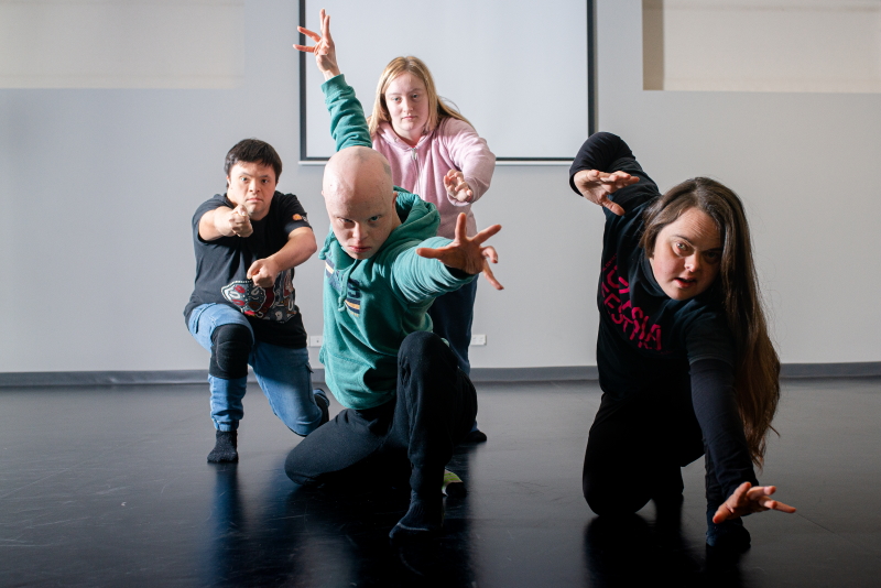 A photo of four dancers striking a pose