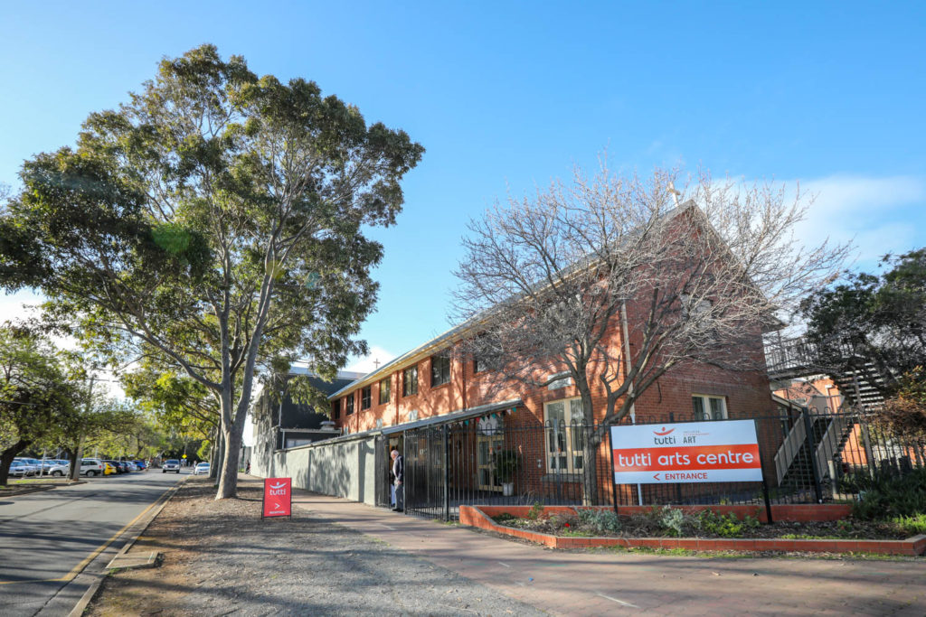 A photo of the exterior of a two storey building with signs saying Tutti Arts Centre.